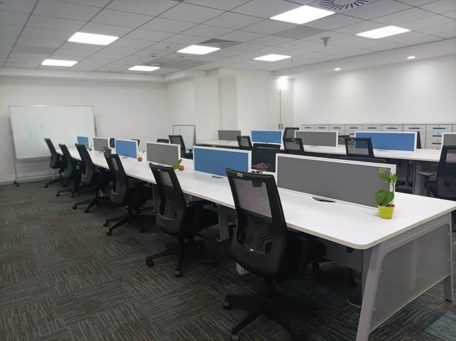 Discussion room with large conference table, ergonomic chairs, and modern lighting