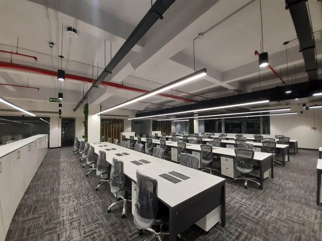 Discussion room with large conference table, ergonomic chairs, and modern lighting