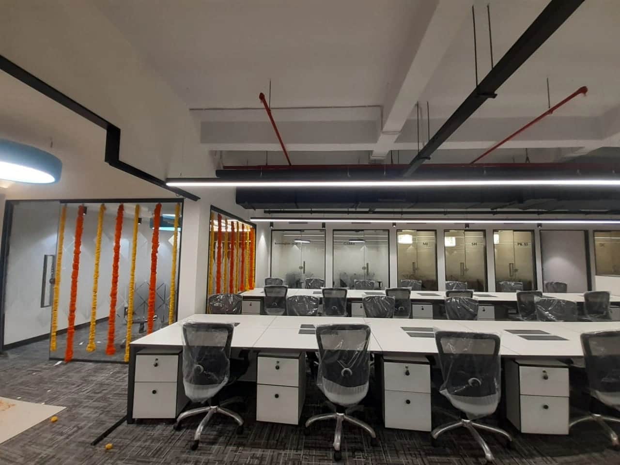 Discussion room with large conference table, ergonomic chairs, and modern lighting