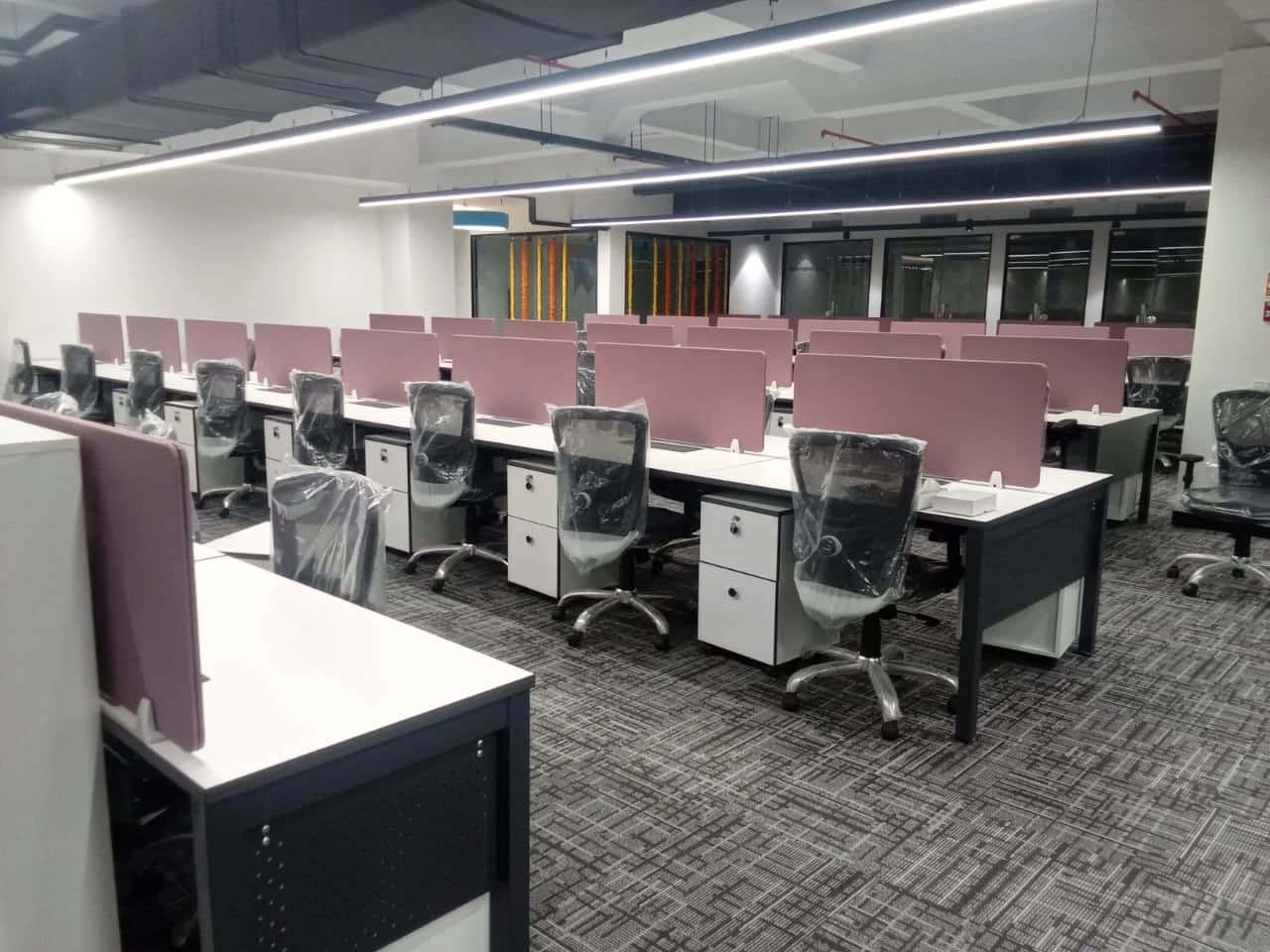 Discussion room with large conference table, ergonomic chairs, and modern lighting