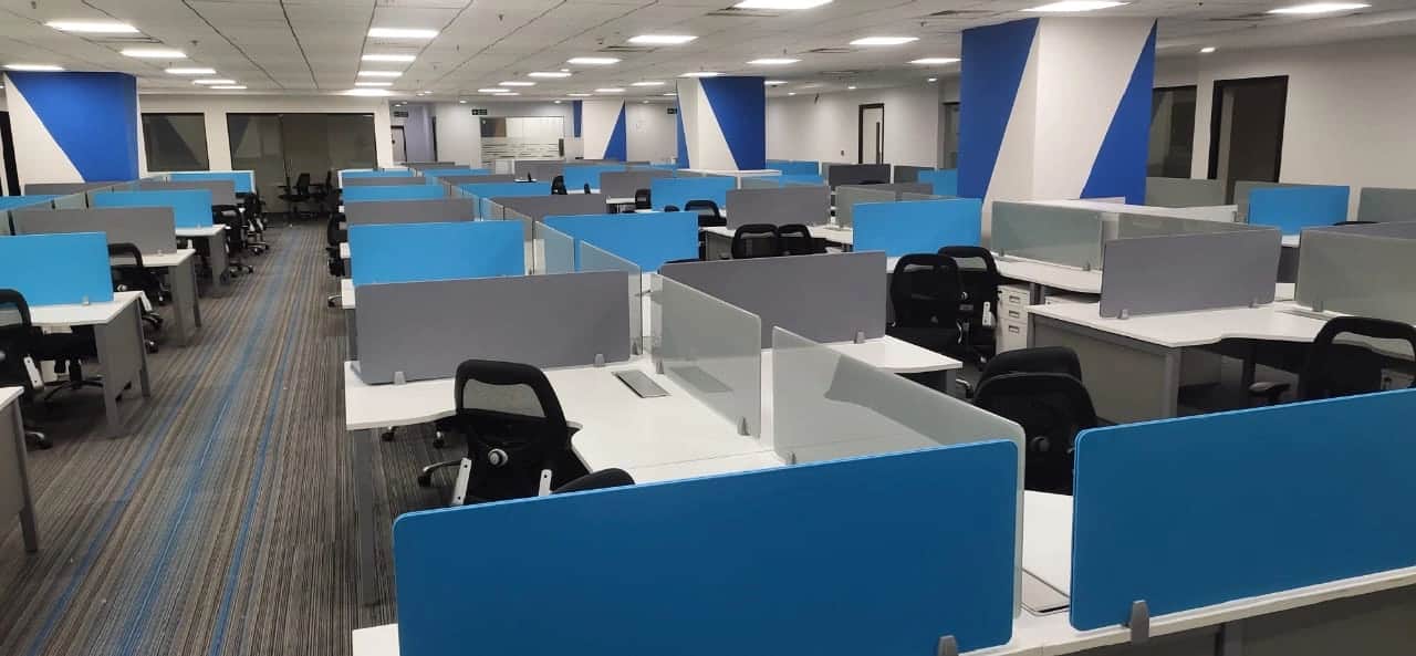 Discussion room with large conference table, ergonomic chairs, and modern lighting