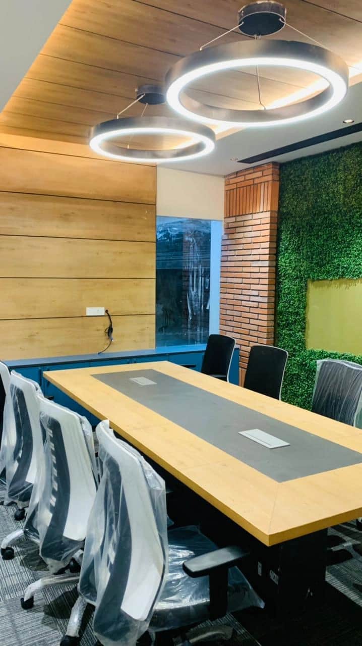 Discussion room with large conference table, ergonomic chairs, and modern lighting