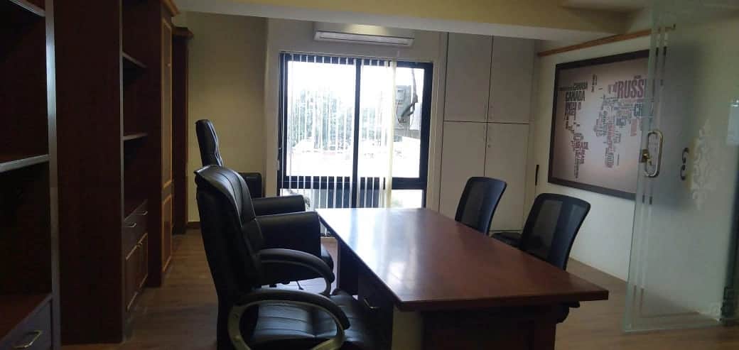 Discussion room with large conference table, ergonomic chairs, and modern lighting